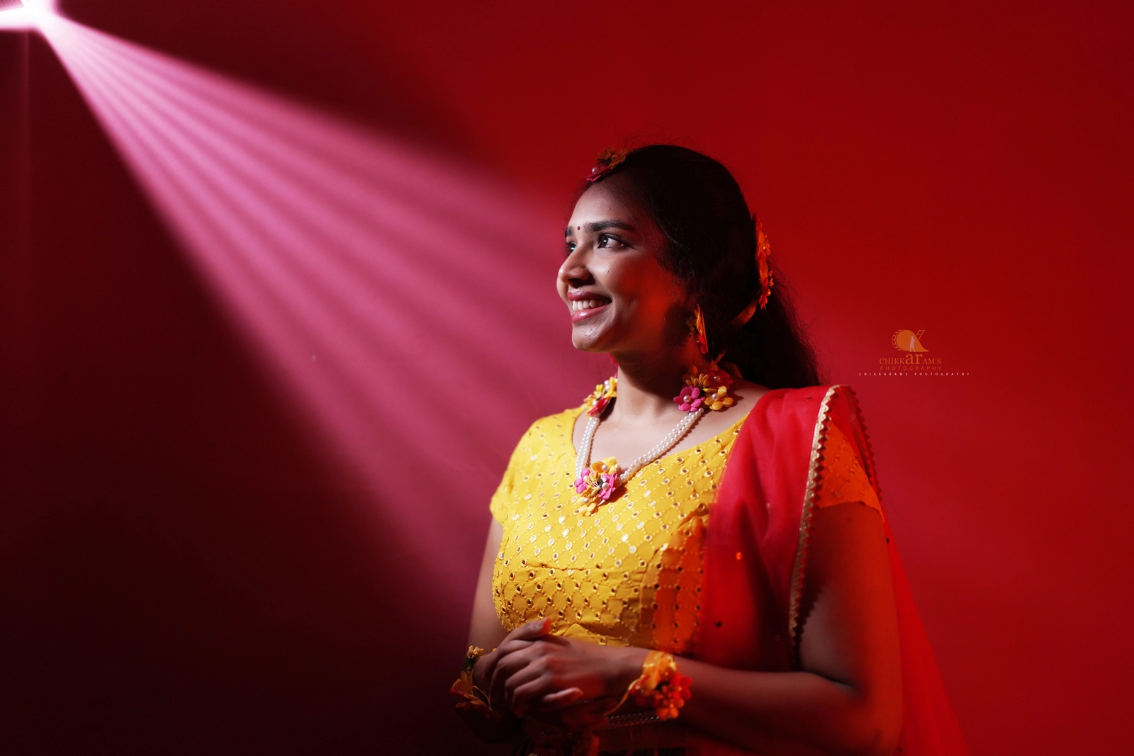 Bride smiling during her haldi ceremony under cinematic lighting – captured by Chikkarams Photography
